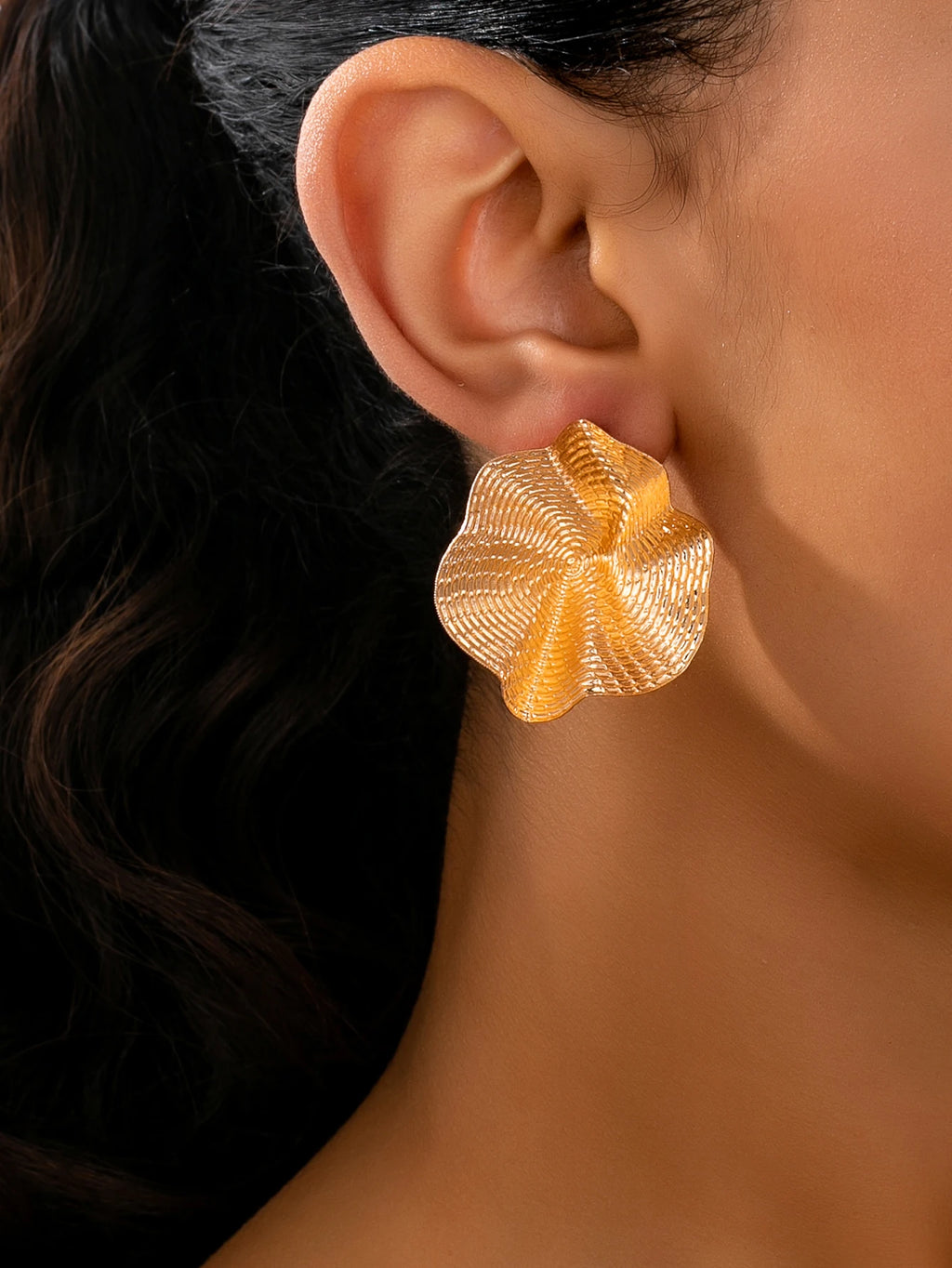Une paire de boucles d'oreilles en métal rondes irrégulières, bijoux L’AURA