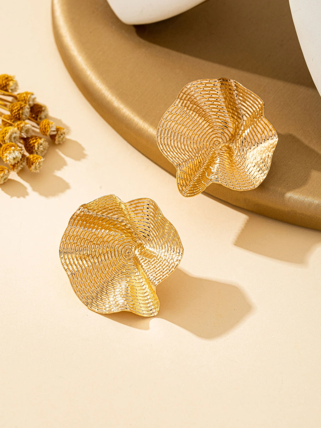 Une paire de boucles d'oreilles en métal rondes irrégulières, bijoux L’AURA