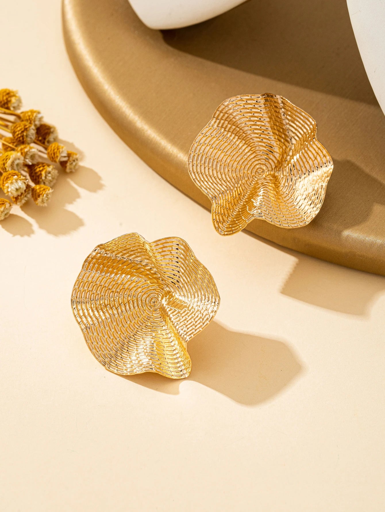 Une paire de boucles d'oreilles en métal rondes irrégulières, bijoux L’AURA
