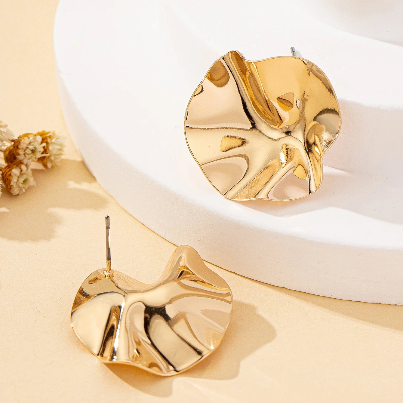 Une paire de boucles d'oreilles en métal rondes irrégulières, bijoux L’AURA
